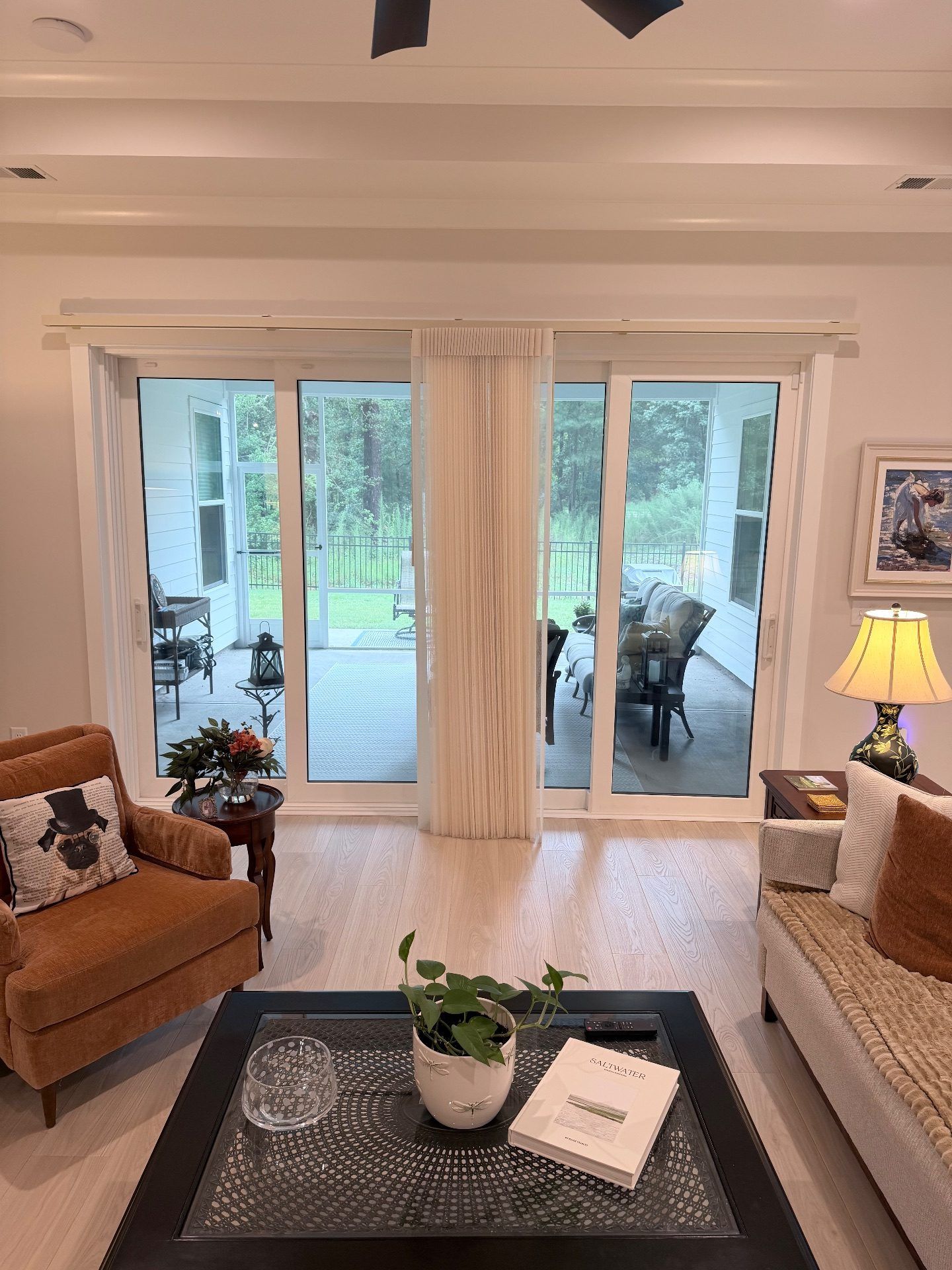 Smart Drape Stacked in the center over a large sliding glass door in a Living Room at Toll Brothers Ocean Isle Palms