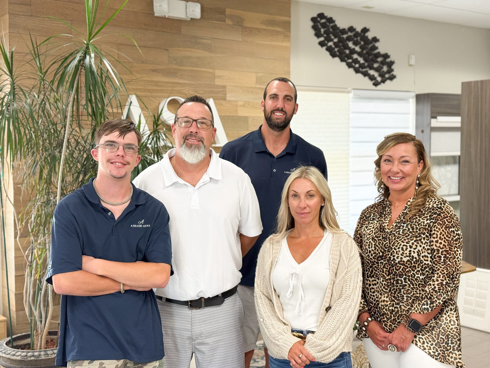 The A Shade Above Coastal crew standing together inside the Cherry Grove showroom.